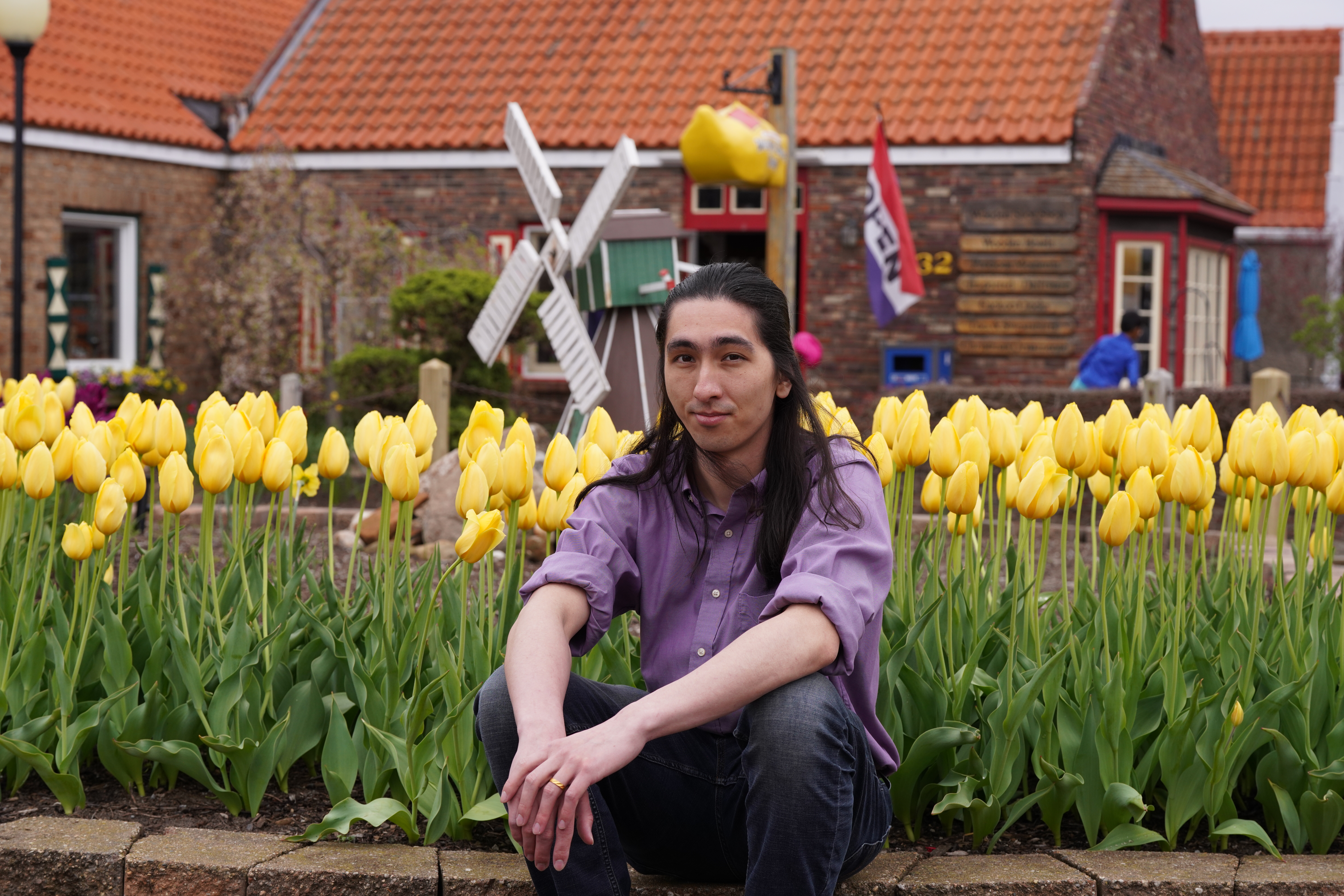 Andrew Folkler Sitting In Front of Tulips.